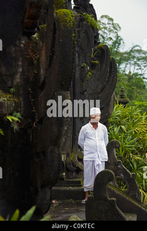 Un indù santo uomo attende adoratori presso il più importante tempio di Bali, Indonesia, Besakih o anche chiamato il Tempio madre. Foto Stock