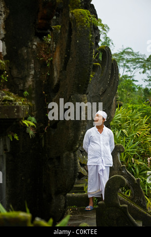 Un indù santo uomo attende adoratori presso il più importante tempio di Bali, Indonesia, Besakih o anche chiamato il Tempio madre. Foto Stock