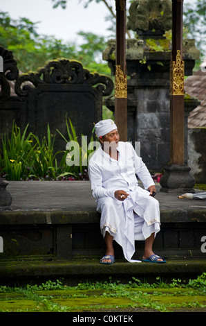 Un indù santo uomo attende adoratori presso il più importante tempio di Bali, Indonesia, Besakih o anche chiamato il Tempio madre. Foto Stock