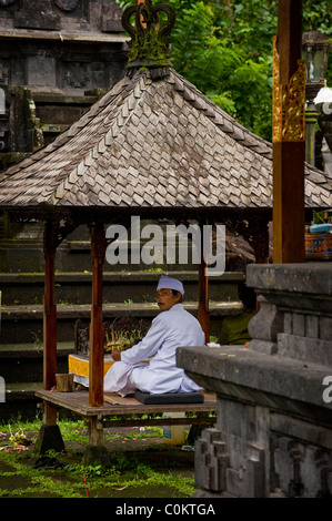 Un indù santo uomo attende adoratori presso il più importante tempio di Bali, Indonesia, Besakih o anche chiamato il Tempio madre. Foto Stock