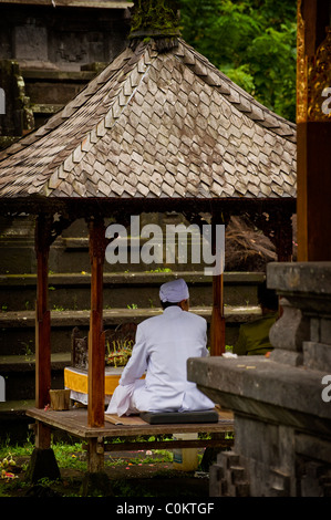 Un indù santo uomo attende adoratori presso il più importante tempio di Bali, Indonesia, Besakih o anche chiamato il Tempio madre. Foto Stock