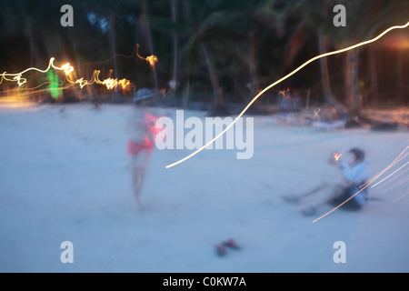 Turisti asiatici scattare fotografie durante il tramonto a spiaggia bianca. Il Boracay, Foto Stock