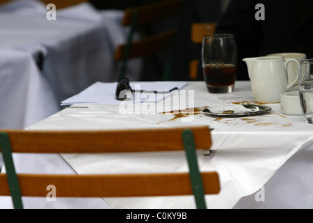 Dale Winton lascia una punta piccola e grande pasticcio sulla sua tavola dopo aver gustato un caffè con un amico al di fuori di un cafe in west Foto Stock