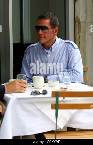 Dale Winton lascia una punta piccola e grande pasticcio sulla sua tavola dopo aver gustato un caffè con un amico al di fuori di un cafe in west Foto Stock