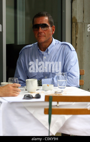 Dale Winton lascia una punta piccola e grande pasticcio sulla sua tavola dopo aver gustato un caffè con un amico al di fuori di un cafe in west Foto Stock