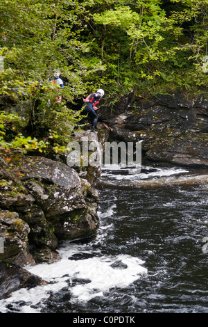 Gorge walking, noto anche come canyoning a cadute di Falloch appena fuori la A82 a poche miglia a sud di Crianlarich, Scozia Foto Stock