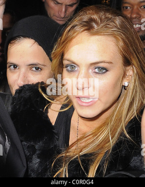 Lindsay Lohan e Sam Ronson lasciando Chinawhites nightclub che appaiono piuttosto peggio per usura, ed essendo trattenuto da uno dei suoi Foto Stock