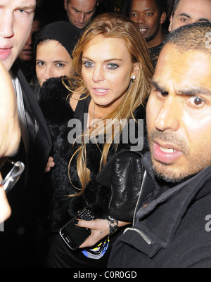 Lindsay Lohan e Sam Ronson lasciando Chinawhites nightclub che appaiono piuttosto peggio per usura, ed essendo trattenuto da uno dei suoi Foto Stock