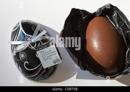 Tesco Finest cioccolato al latte uova pasquali con Marc de Champagne tartufi aperto e srotolata su sfondo bianco Foto Stock