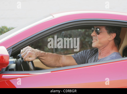 Sylvester Stallone e amici hanno il pranzo al Cafè Roma. Sly unità off in un rosso Ferrari. Los Angeles, California, Stati Uniti d'America - Foto Stock