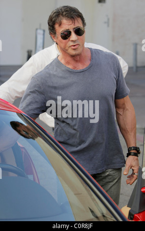 Sylvester Stallone e amici hanno il pranzo al Cafè Roma. Sly unità off in un rosso Ferrari. Los Angeles, California, Stati Uniti d'America - Foto Stock