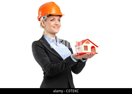 Un sorridente forewoman indossando il casco e tenendo un modello di casa Foto Stock