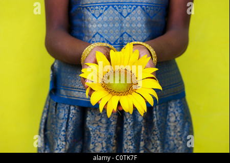 Giovane ragazza indiana holding di semi di girasole. Andhra Pradesh, India Foto Stock