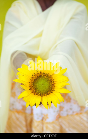 Giovane ragazza indiana holding di semi di girasole. Andhra Pradesh, India Foto Stock