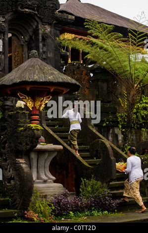 Hindu devoti venuti per il più importante tempio di Bali, Indonesia-Besakih, o il Tempio madre di lasciare offerte e pregare. Foto Stock