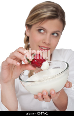 Uno stile di vita sano series - Donna azienda fragola con yogurt su sfondo bianco Foto Stock