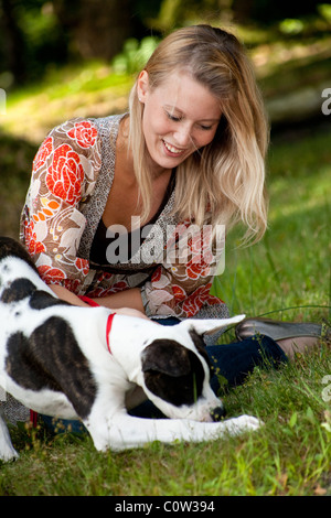 Ragazza bionda e un bulldog americano nel parco Foto Stock