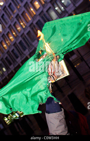 Londra, Regno Unito. Durante una manifestazione di protesta al di fuori dell'ambasciata statunitense di manifestanti libici masterizzare Gheddafi libro verde e bandiera. Foto Stock