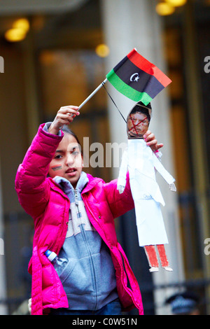 Londra, Regno Unito. Ragazza giovane pende l'effige di Gheddafi Foto Stock