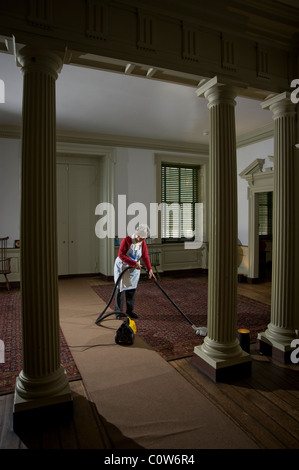 Donna anziana aspirare grandi corridoio in casa storica, Philadelphia, Stati Uniti d'America Foto Stock