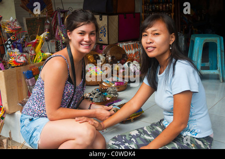 Contrattazione turistica con il negoziante per acquistare souvenir a Ubud, Bali, Indonesia Foto Stock