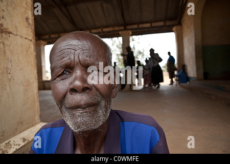 Un anziano si trova al di fuori di un centro di salute in Kumi, Uganda, Africa orientale. Foto Stock