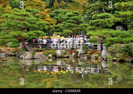 A scuola i ragazzi e le ragazze della scuola visitando il parco del tempio d'Oro Kyoto in Giappone Foto Stock