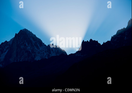 Raggi di sole precedere il sorgere del sole all'alba nella valle di Chamonix nelle Alpi francesi. Foto Stock