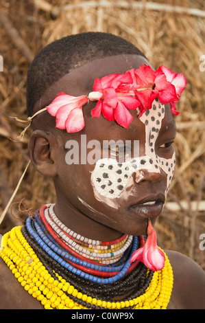 Karo ragazza con un archetto floreali, pitture facciali, Omo river valley, sud Etiopia Foto Stock