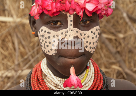 Karo ragazza con un archetto floreali, pitture facciali, Omo river valley, sud Etiopia Foto Stock