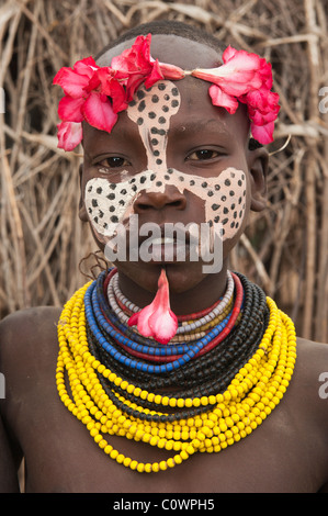 Karo ragazza con un archetto floreali, pitture facciali, Omo river valley, sud Etiopia Foto Stock