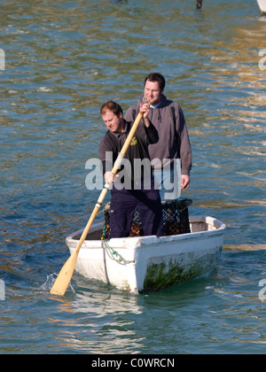 Fisherman sbarcano in barca a remi, Cornwall, Regno Unito Foto Stock