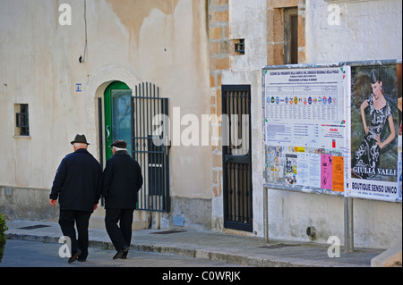 L'Italia, Cisternino, due uomo vecchio a piedi attraverso la città vecchia Foto Stock