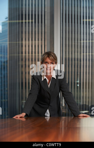 Business donna appoggiata su una sedia nella sala riunioni guardando la fotocamera Foto Stock