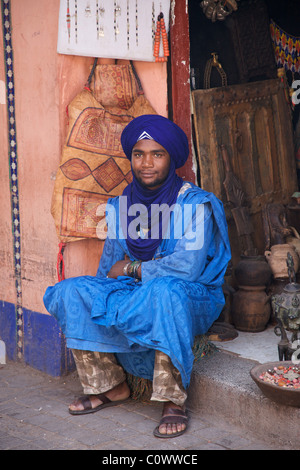 Un 'Blue Man" mercato trader di fronte al suo negozio nel souk, medina di Marrakech, Marocco, Africa del nord Foto Stock