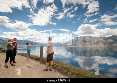 Visite turistiche i turisti stop al Lago Hawea per una fotografia opportunità. Vicino a Wanaka. Isola del Sud, Nuova Zelanda. Foto Stock