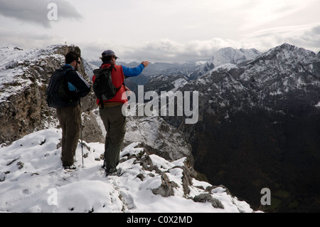 Due escursionisti a piedi attraverso la coperta di neve montagne di Ponga, Asturias, Spagna. Foto Stock