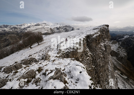 Due escursionisti a piedi attraverso la coperta di neve montagne di Ponga, Asturias, Spagna. Foto Stock