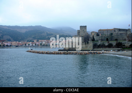 Veduta del porto di Collioure Francia in inverno al tramonto con nuvole e montagne (fondo) Foto Stock