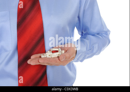 Il bianco e il rosso compresse in mani maschio Foto Stock