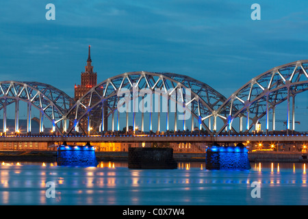 Il fiume di notte con il ponte e la riflessione in Riga Foto Stock