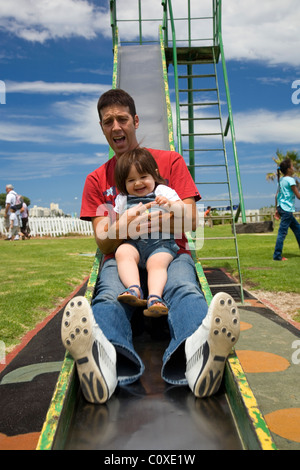 Padre e figlia andando giù scorrere al parco giochi Foto Stock