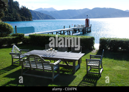 Al di fuori di una zona pranzo con vista sui suoni, vicino a Picton in Nuova Zelanda, dal balcone del pesce pigro bach (homestead) Foto Stock