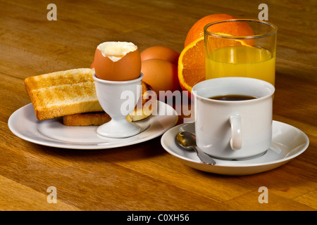Colazione: uova sode, toast, caffè e succo di frutta fresco. Sul tavolo di legno Foto Stock