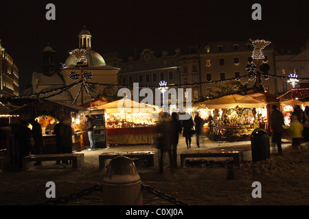 Il mercatino di Natale sulla piazza del Mercato di Cracovia in serata. La Polonia. Foto Stock