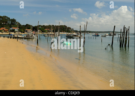 Shore davanti con poli mostra oyster letti di raccolta in Cap Ferret, baia di Arcachon, Dipartimento della Gironde, Francia Foto Stock