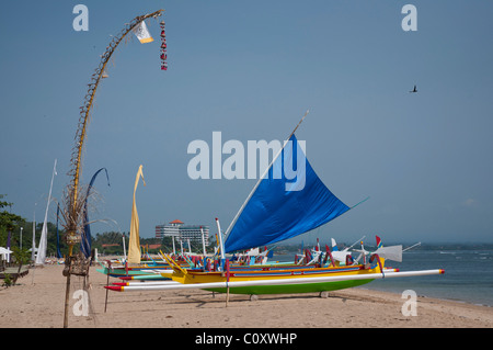 Barca da pesca balinese dai colori vivaci chiamata jukung sulla spiaggia di Sanur Bali Indonesia Foto Stock