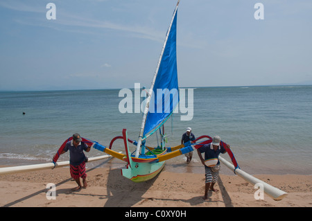 Barca da pesca balinese dai colori vivaci chiamata jukung sulla spiaggia di Sanur Bali Indonesia Foto Stock