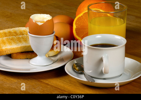 Colazione: uova sode, toast, caffè e succo di frutta fresco. Sul tavolo di legno Foto Stock