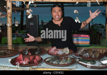 Un estroverso ristoratore mostra la sua mercanzia in un ristorante di pesce sull'isola di Gili Trawangan vicino a Lombok Indonesia Foto Stock